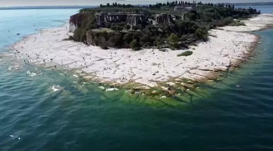 Seca faz surgir praia rochosa em lago na Italia